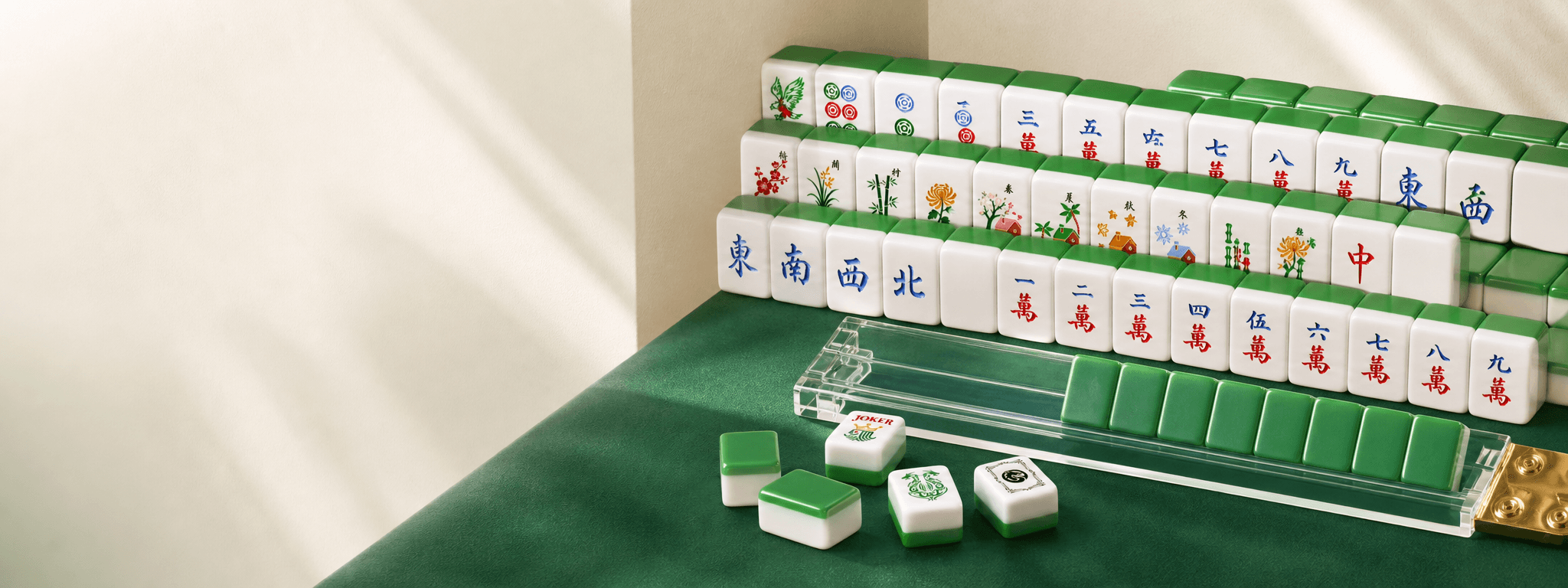 Green and white Mahjong tiles with a clear acrylic rack on an emerald green table